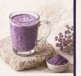 Mug of UBÉRA ube latte on alpine stone