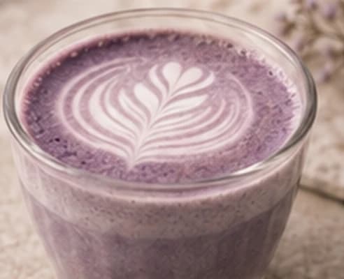 Makroaufnahme des violetten Ube-Latte und seines Schaummusters