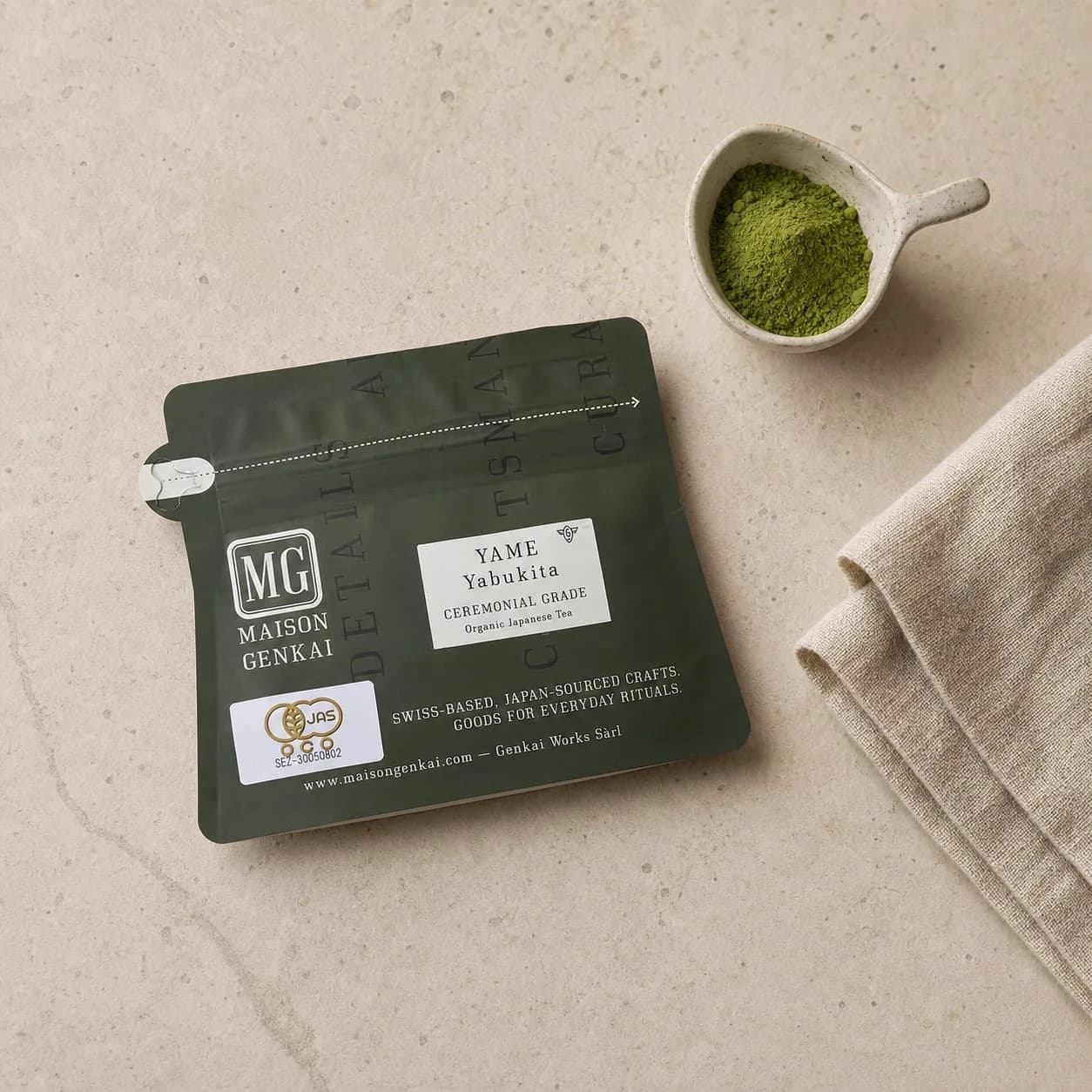 Maison Genkai organic Yame matcha (Yabukita) pouch next to a small scoop of matcha powder