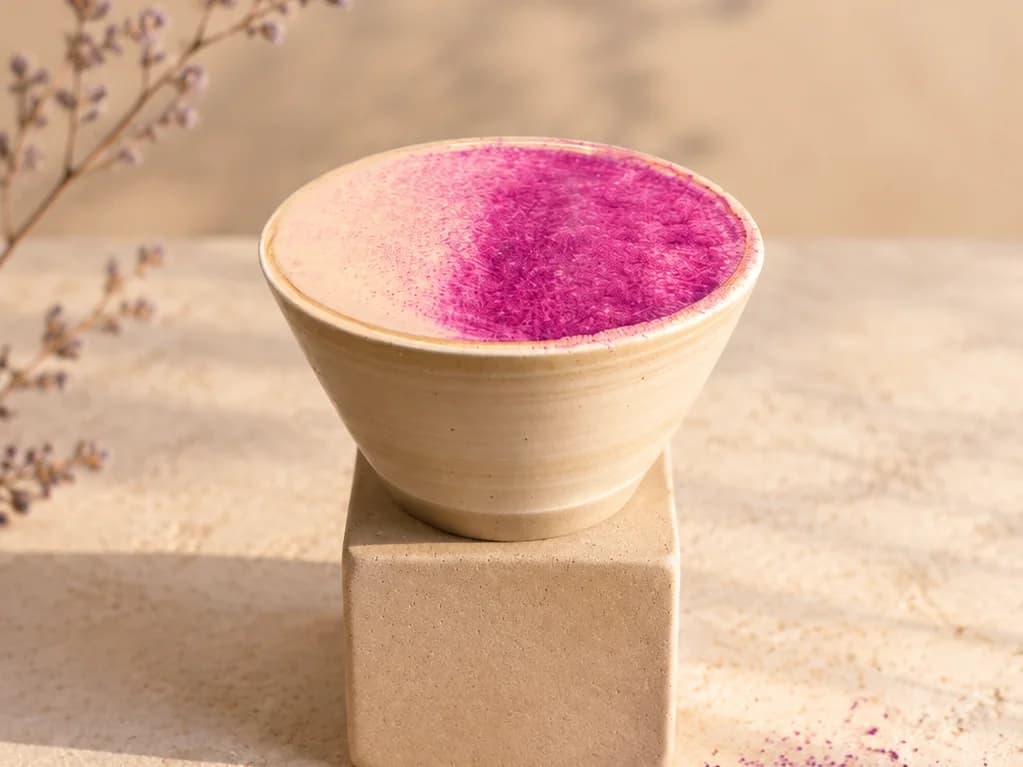 Bol en céramique rempli de poudre d’ube violette, posé sur un cube de pierre